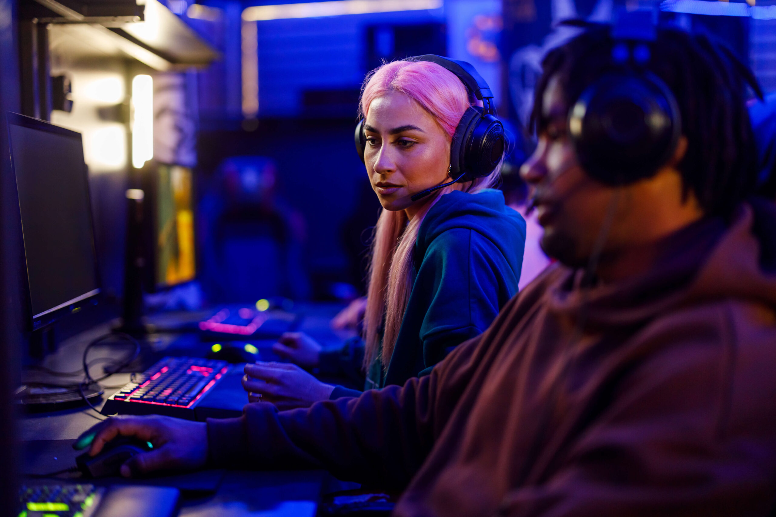 female with pink hair gamer looking at her friend 2024 03 25 23 52 41 utc 1 scaled 1