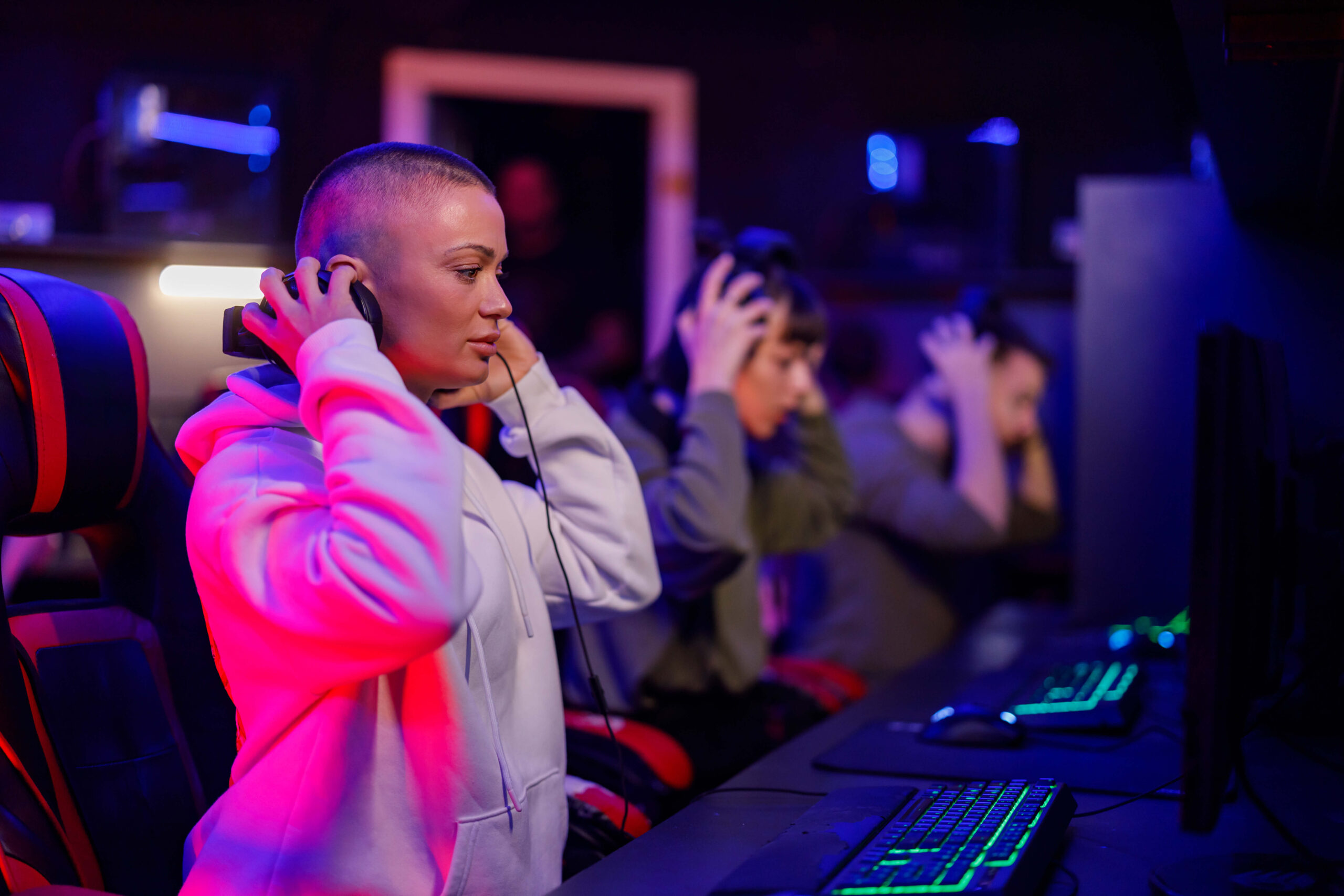 young bald female gamer putting headphones and pla 2024 03 12 20 07 26 utc 1 scaled 1